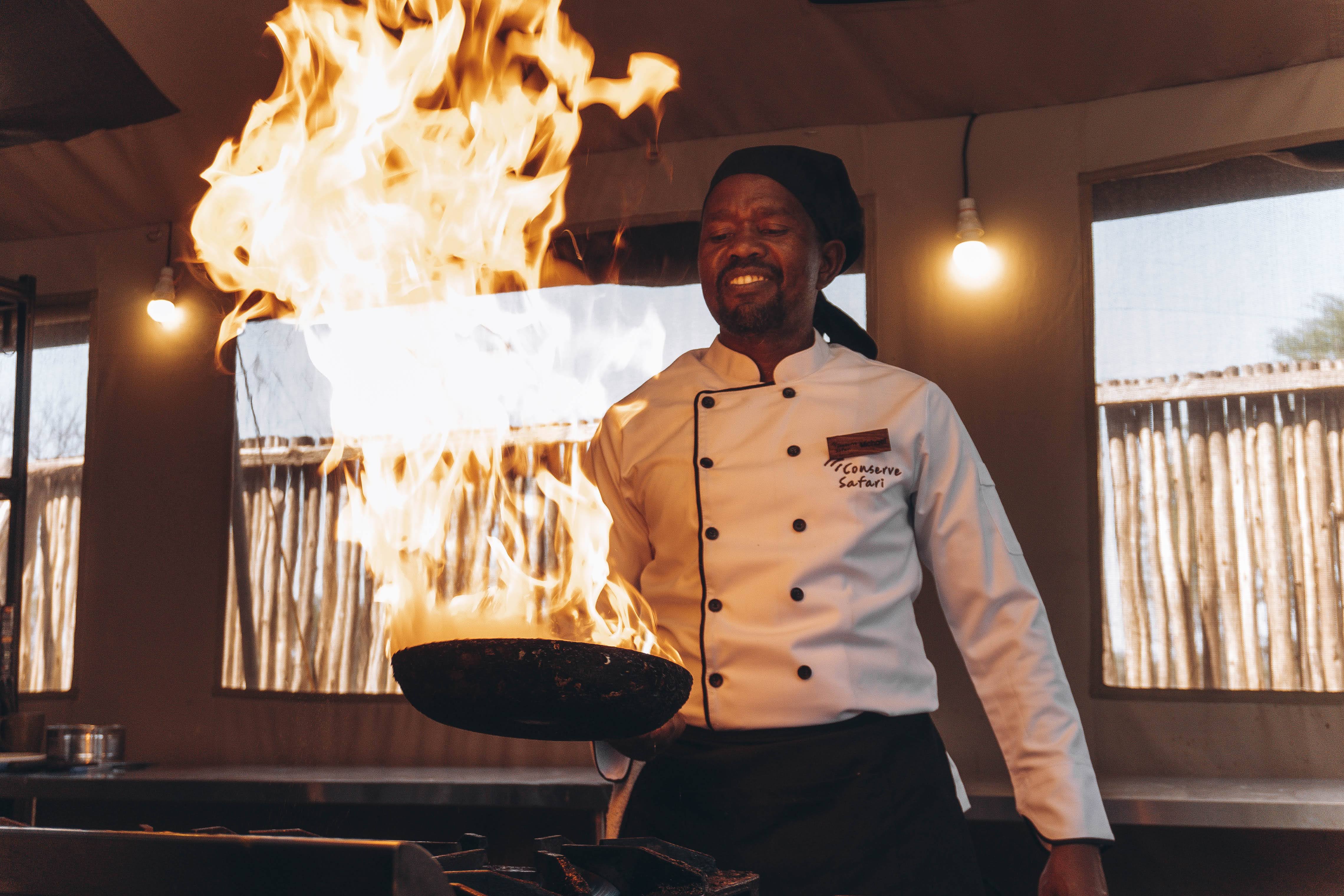 Conserve Safari Serengeti chef flambéing in the gourmet kitchen