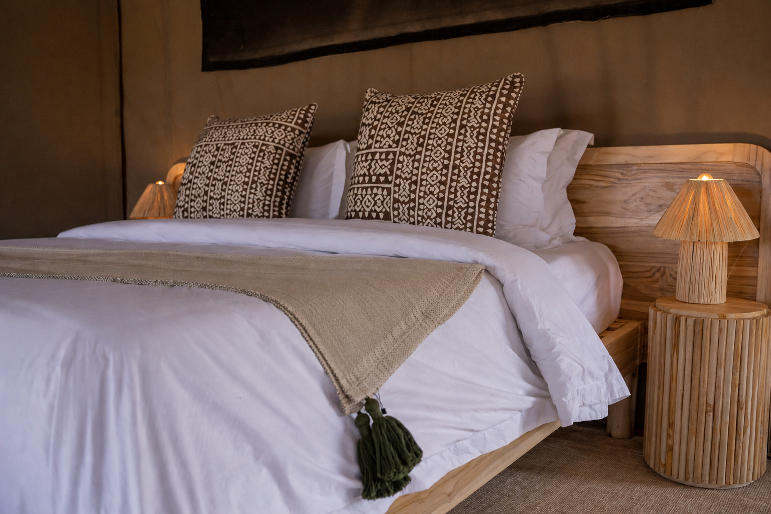 Luxury king bed with African cushions and linen throw at Conserve Safari Tarangire