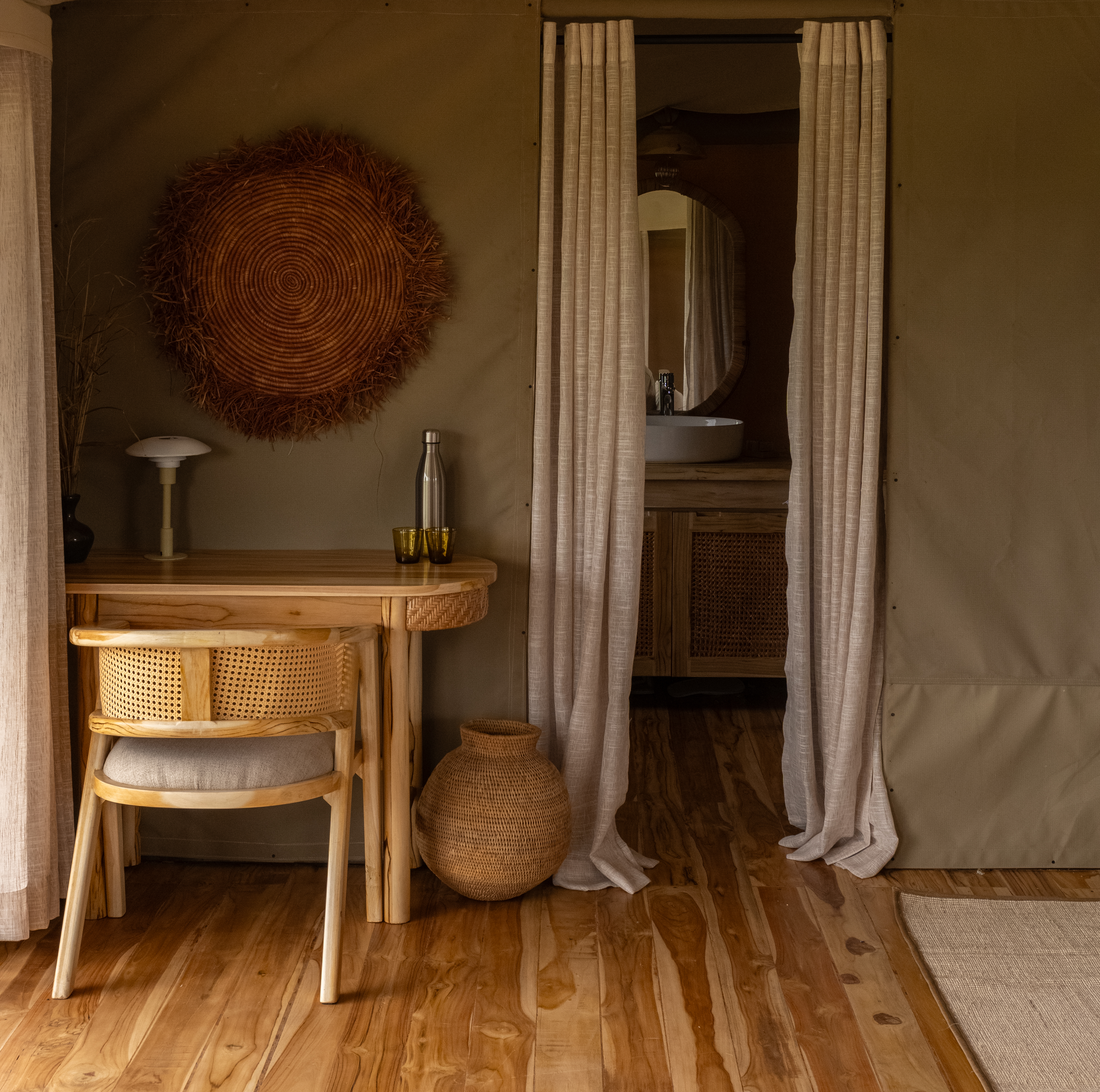 Luxury suite interior with rattan desk and African wall art at Conserve Safari Tarangire